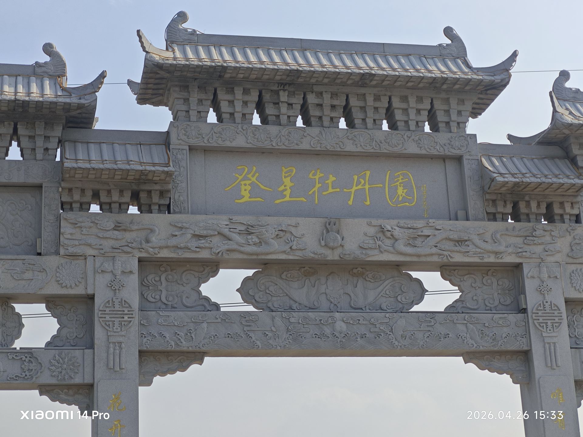圣星牡丹园的中式石牌坊大门，飞檐翘角，古朴庄重，迎接四方来客。