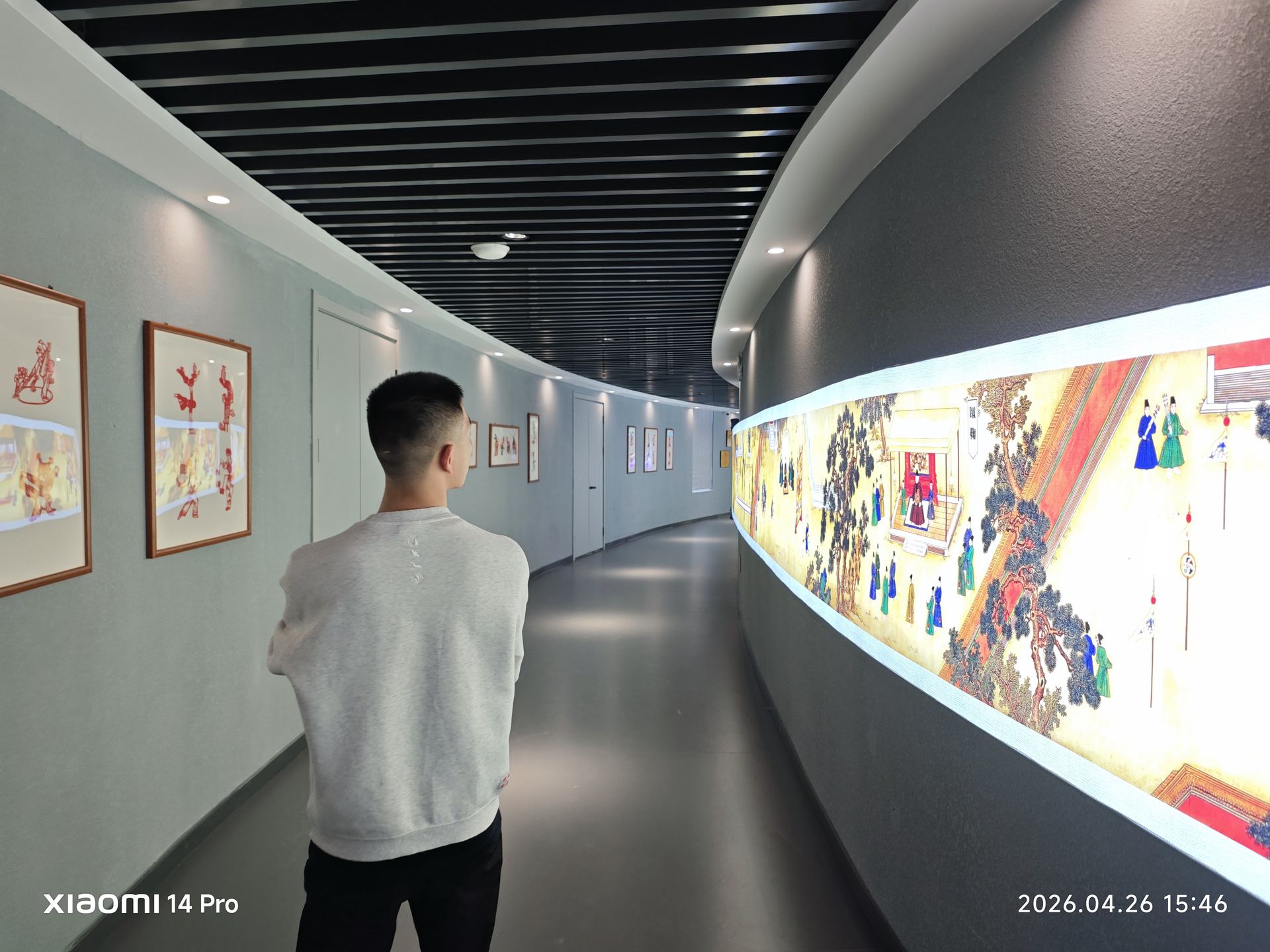 展览长廊中，参观者驻足流连，墙上大幅图文展板将历史徐徐展开。