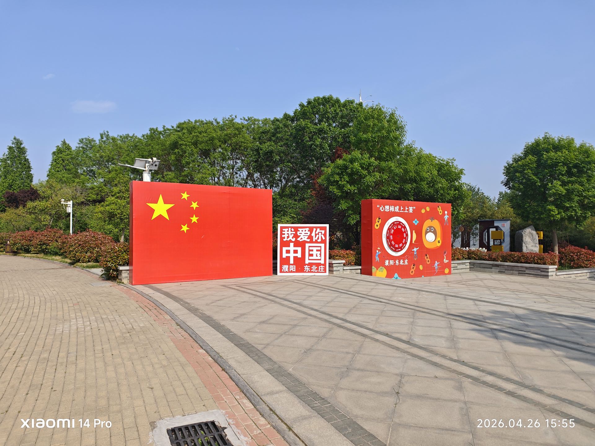 广场上的五星红旗迎风飘扬，'永远跟党走''中国梦'的红色标语彰显时代脉搏。