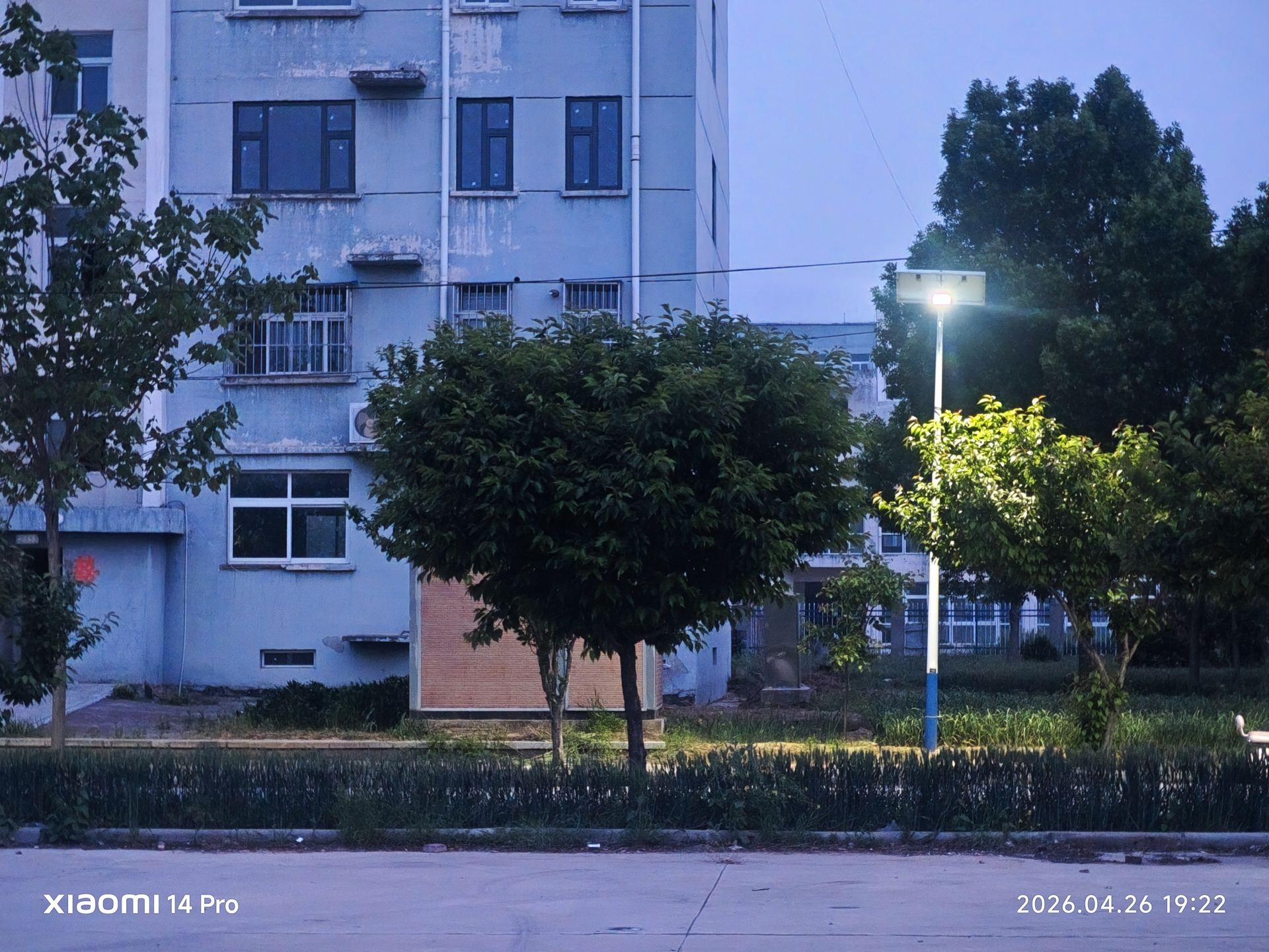 夜幕降临，蓝灰色外墙的楼房在华灯初上的街头安静矗立。