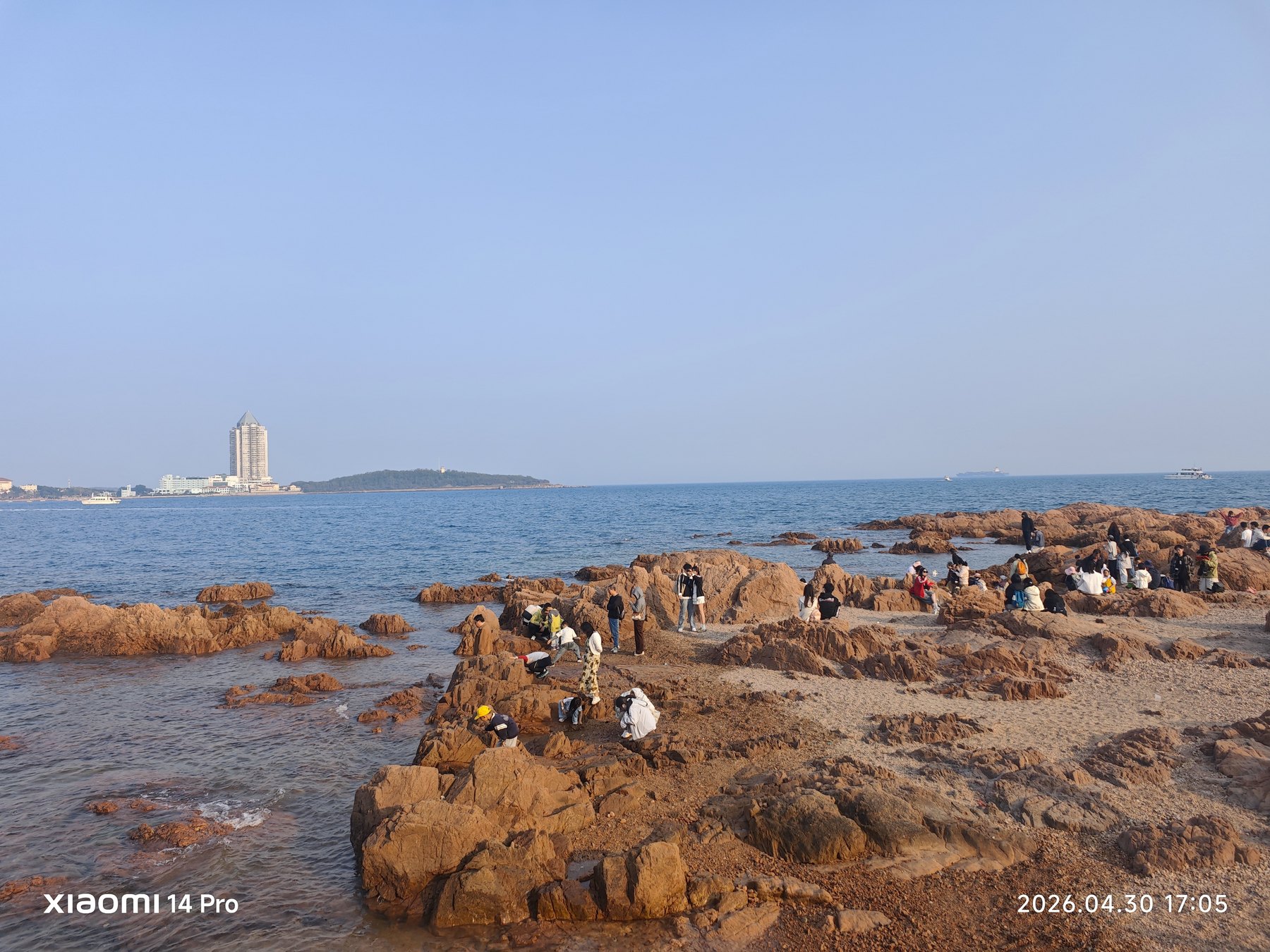 礁石边聚满看海的人,浪声像这座城市最自然的背景音乐。