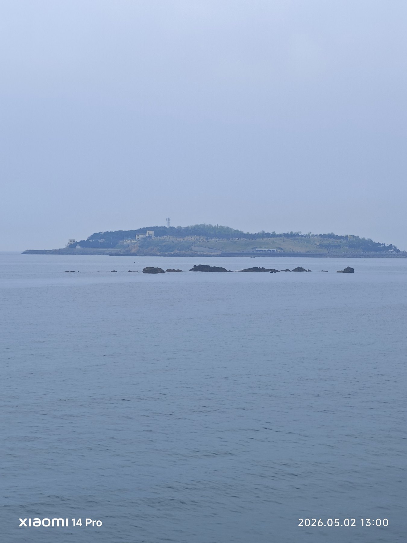 海中央的小岛孤独又清晰,像给灰蓝海面盖了一枚印章。