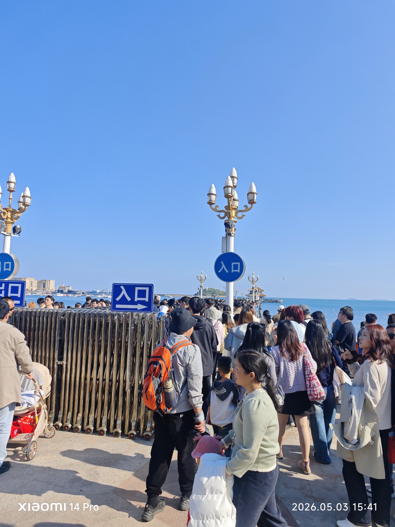 栈桥人潮涌动,海鸥、游客和回澜阁一起成为青岛名片。
